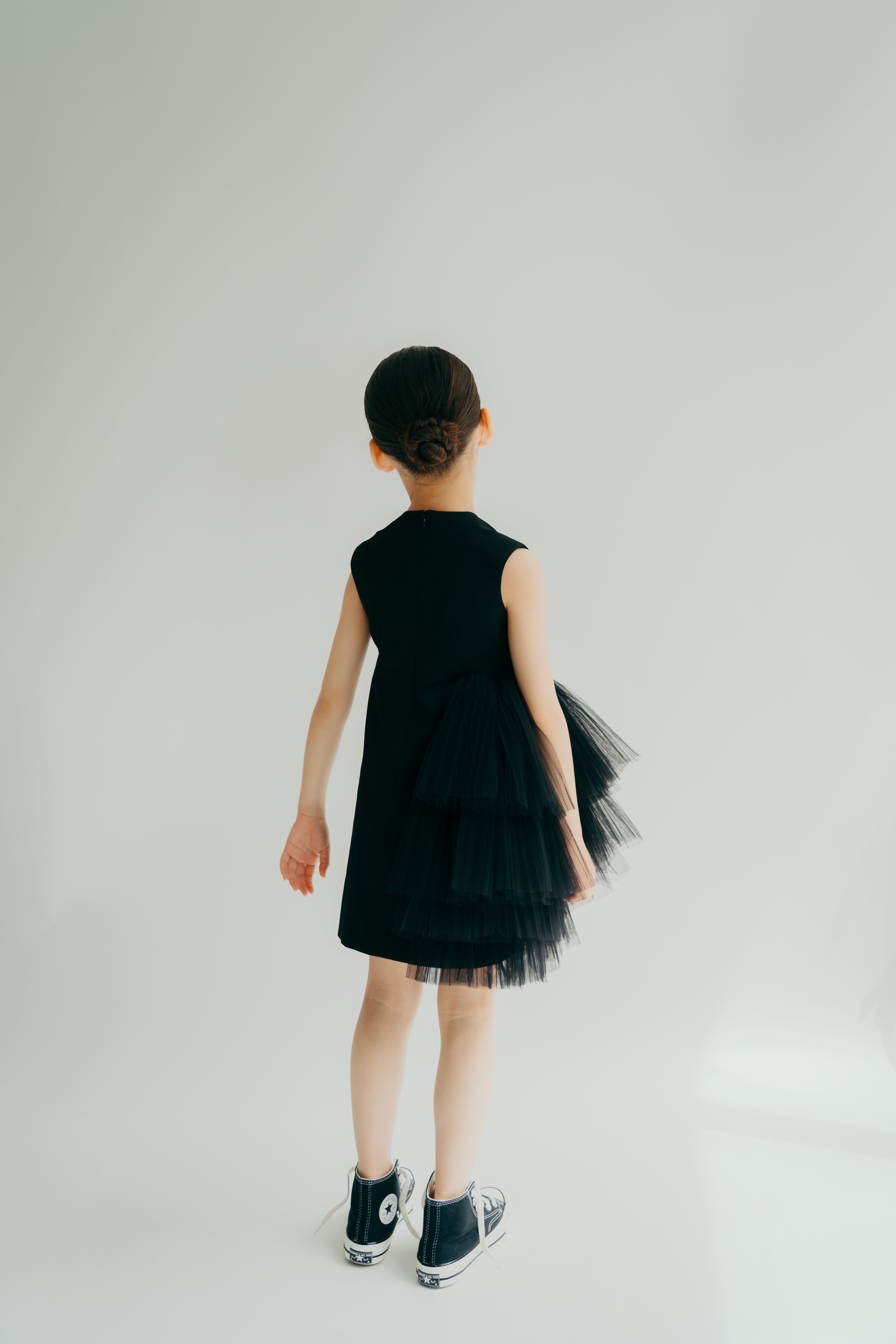 Young girl in kiki black dress from the back