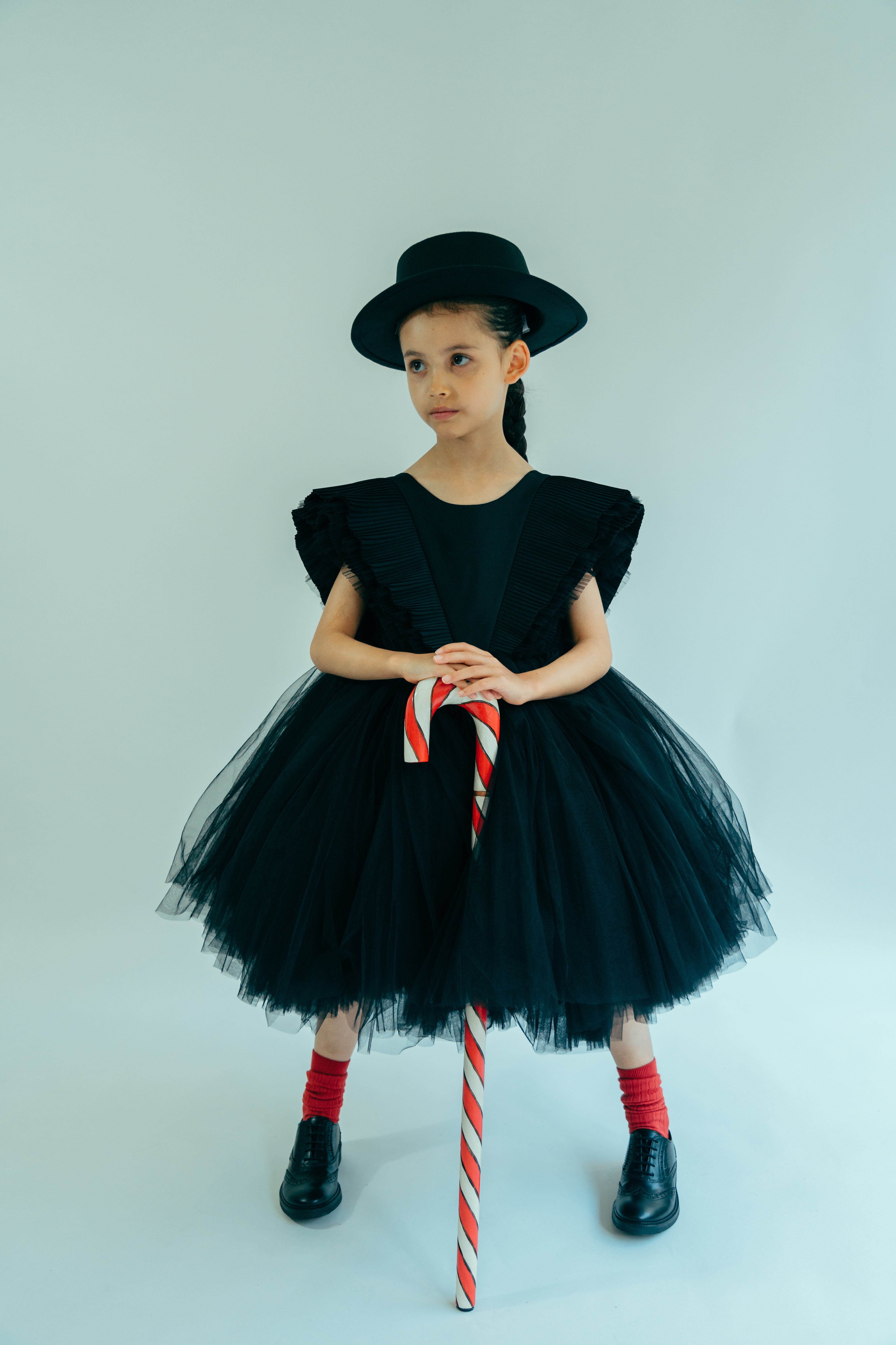 Young girl wearing a black tulle dress with wide and layered sleeves