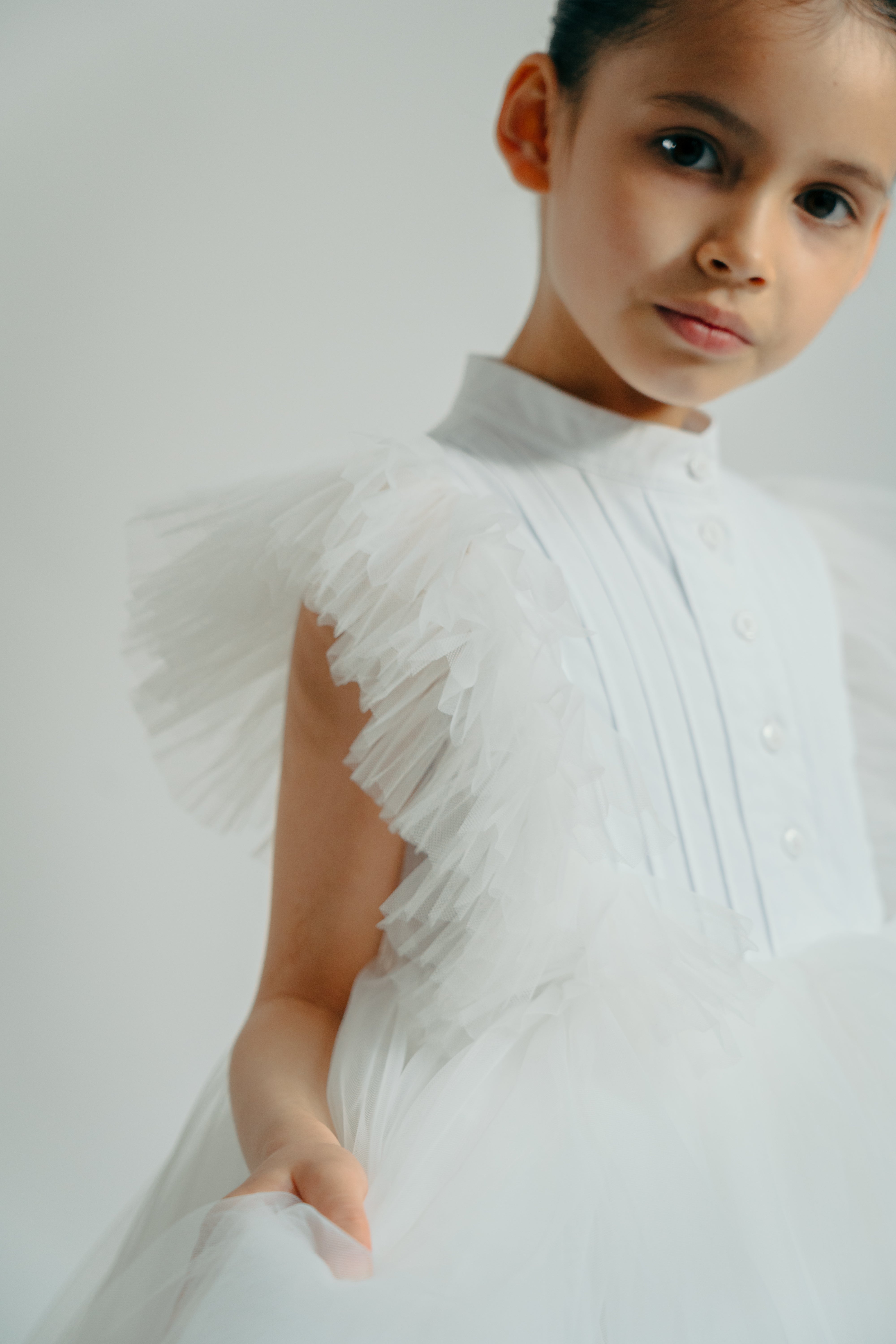 Girl wearing the Francine black dress showing the tulle details on the sleeves