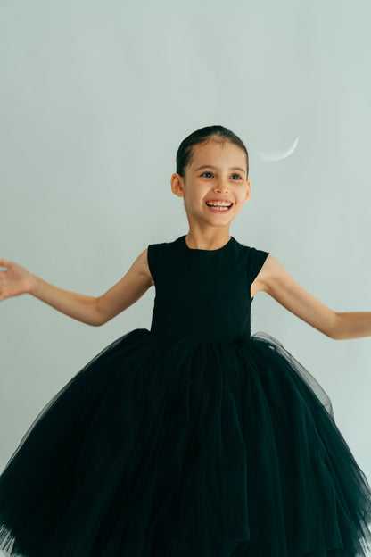 Laughing girl juming in an elegant black dress